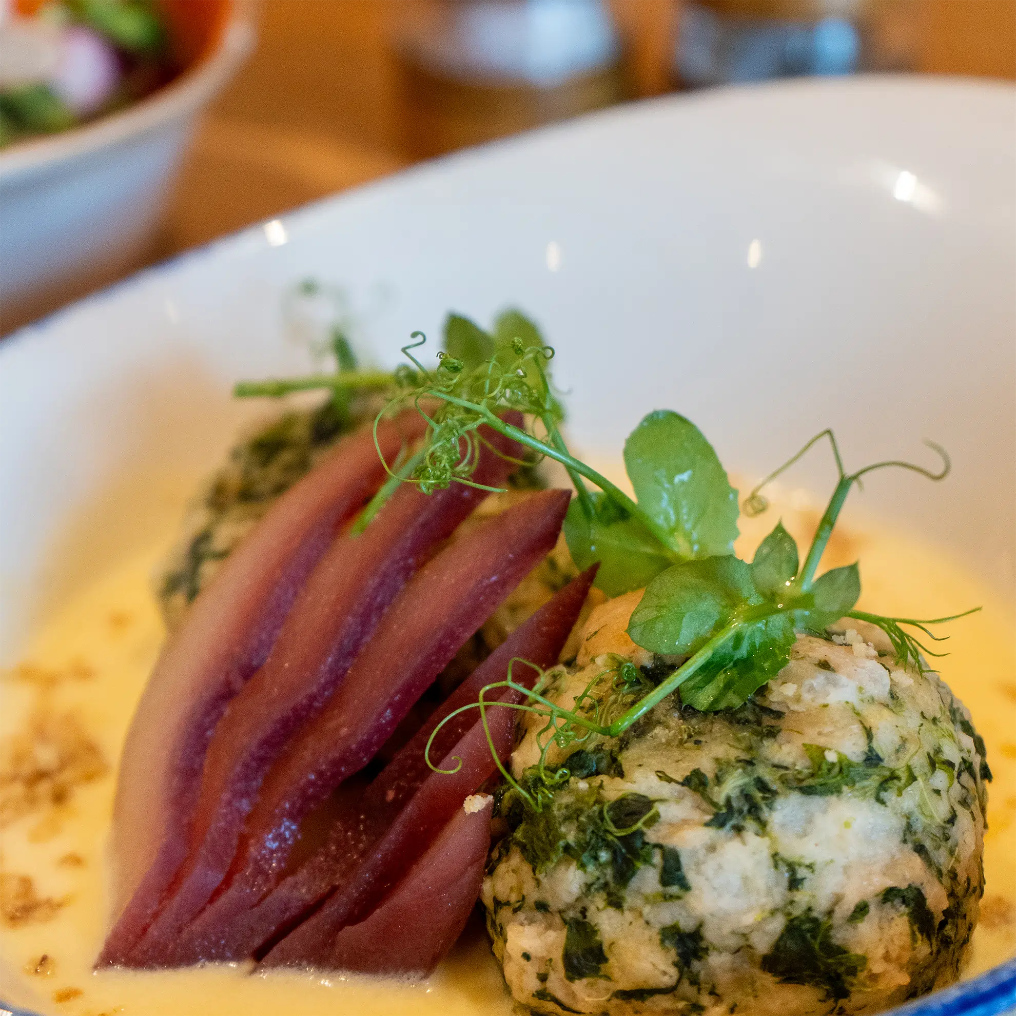 Ein Teller mit Knödeln und Käsesoße